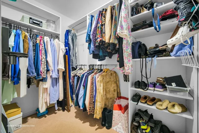 a view of walk in closet with clothes and shoes