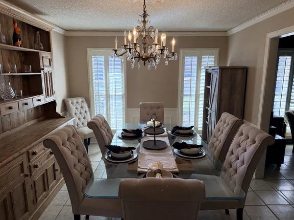 a living room with furniture a chandelier and a flat screen tv