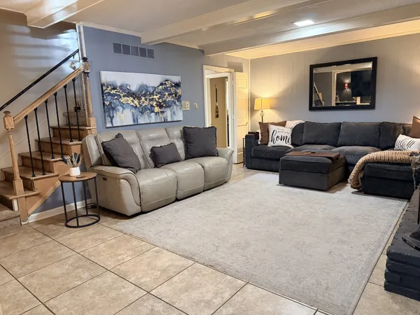 a living room with furniture and a painting on the wall
