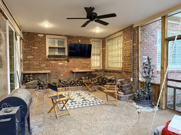 a living room with patio furniture and a flat screen tv