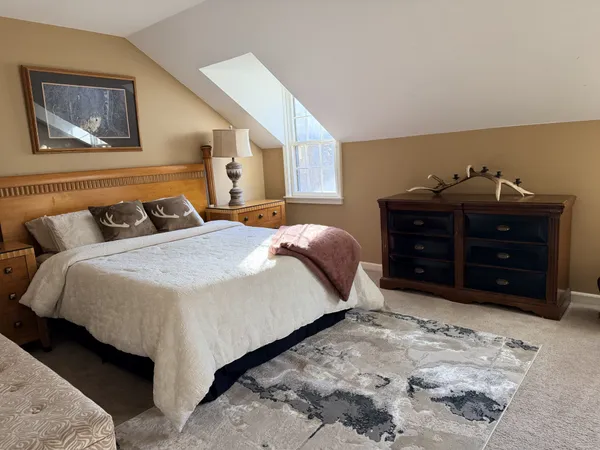 a bedroom with a bed and a painting on the wall