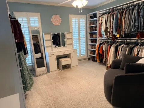 a view of walk in closet with clothes and shoes