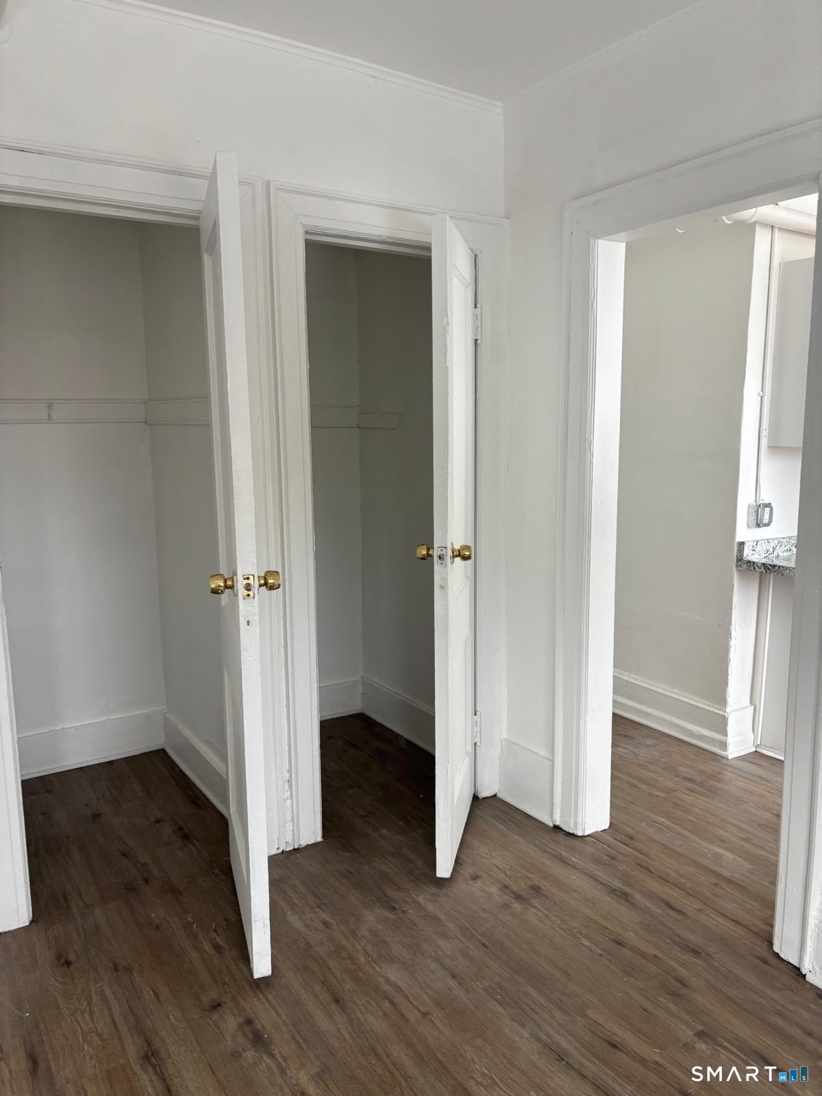 an empty room with wooden floor & entryway