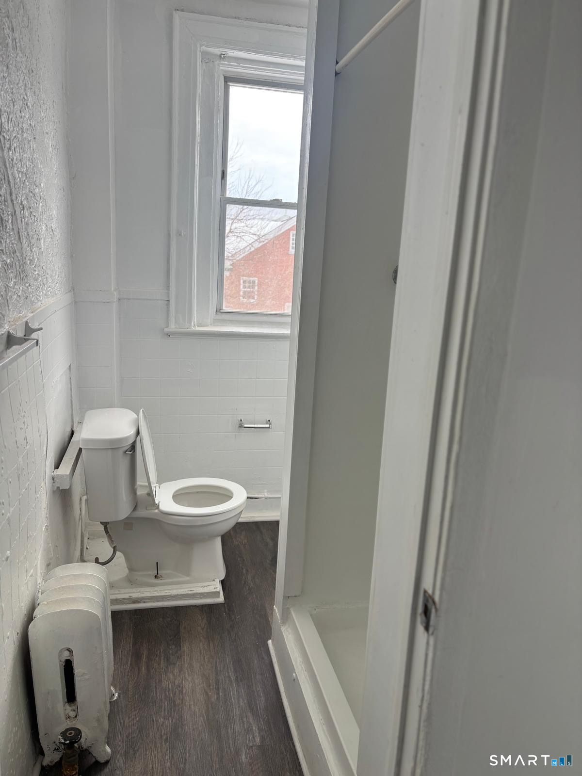 86 Pequonnock Street, Unit 32 Bridgeport, CT 06604 - Photo 3 of 4 a white toilet sitting next to a bathroom sink