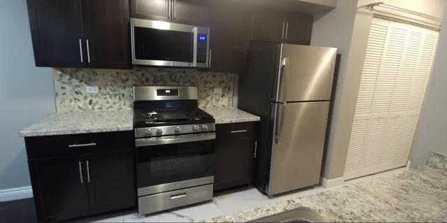 a kitchen with a refrigerator stove and cabinets