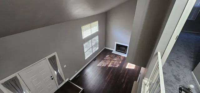 a view of a livingroom with wooden floor and a window