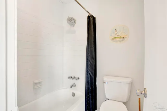 a white toilet sitting next to a bath tub