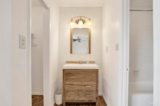 a bathroom with a sink and a mirror with bathtub