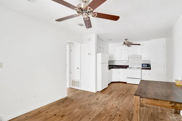 a kitchen with kitchen island white cabinets and refrigerator