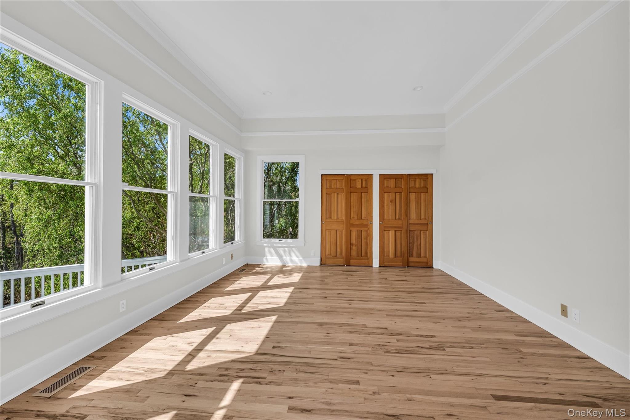 238 Beaver Dam Road Brookhaven, NY 11719 - Photo 20 of 44 a view of an empty room with wooden floor and a window