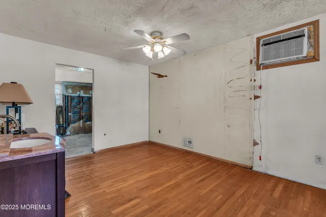 a view of a livingroom with a chandelier fan and wooden floor