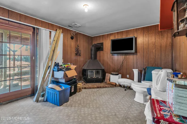 a living room with furniture a flat screen tv and a floor to ceiling window