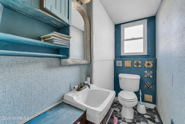 a bathroom with a toilet a sink and a window