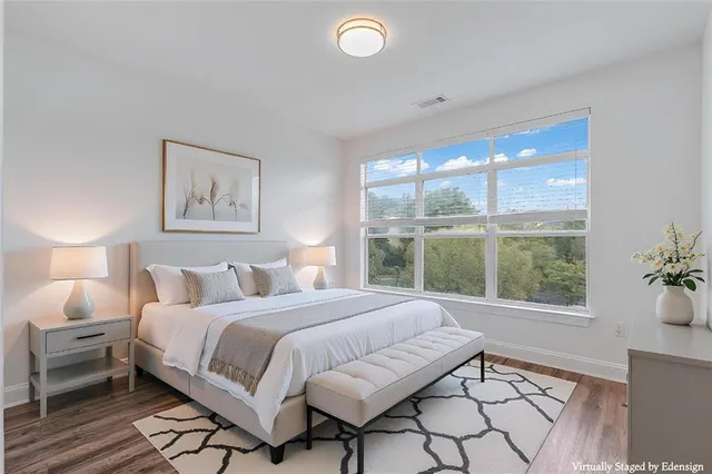 a bedroom with a bed and a large window