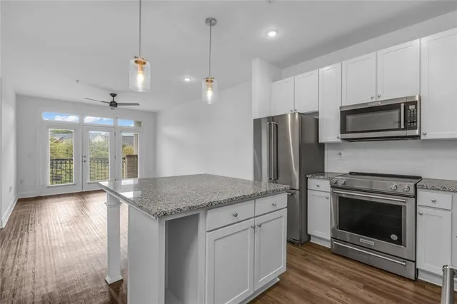 a kitchen with stainless steel appliances granite countertop a stove a sink and a microwave
