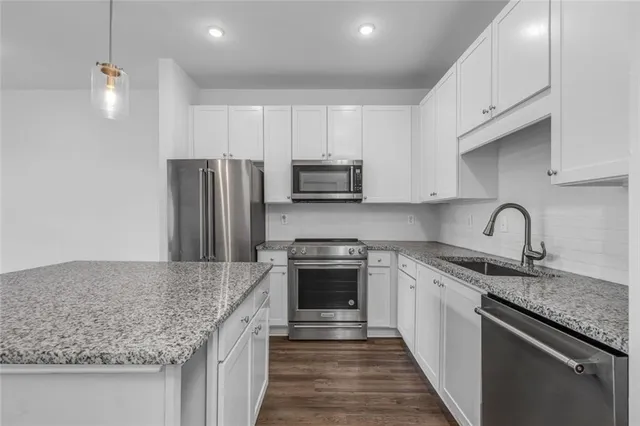 a kitchen with stainless steel appliances granite countertop a sink stove and refrigerator