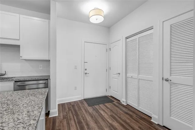 a view of an empty room with wooden floor and cabinets
