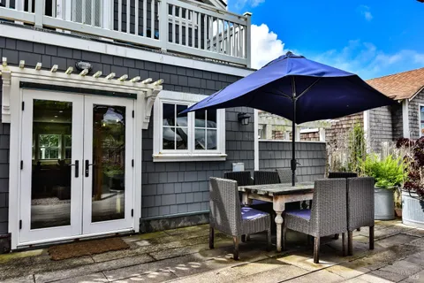a patio with a table and chairs under an umbrella