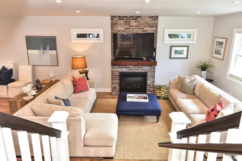 a living room with furniture a flat screen tv and a fireplace