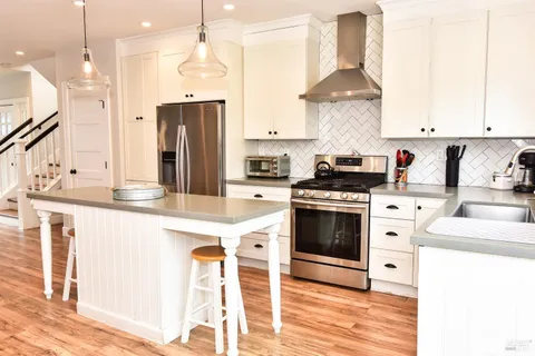 a kitchen with stainless steel appliances granite countertop a stove a sink and a refrigerator