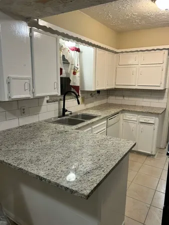a kitchen with sink a counter and cabinets