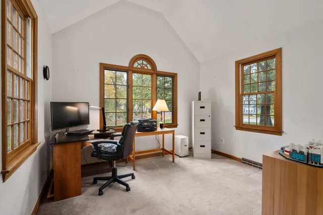 a view of a livingroom with workspace and a window