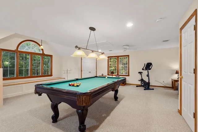 a room with pool table and windows