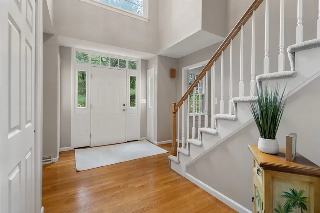 a view of front door with wooden floor and stairs