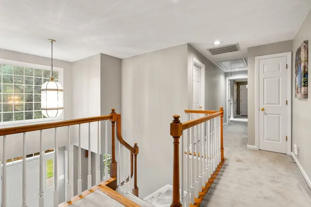 a view of a hallway with wooden floor and windows