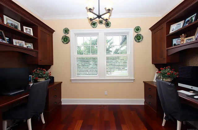 a workspace with furniture a chandelier and wooden floor