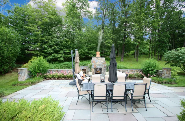 a view of a patio with table and chairs potted plants with large tree