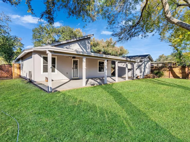 a front view of a house with a yard and tree