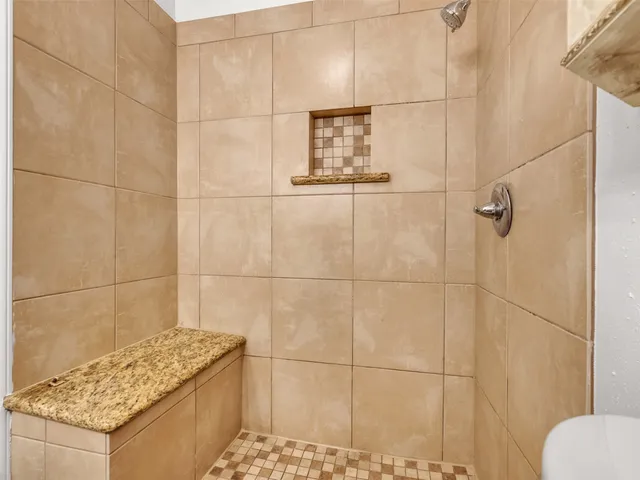 a bathroom with a granite countertop shower and a sink