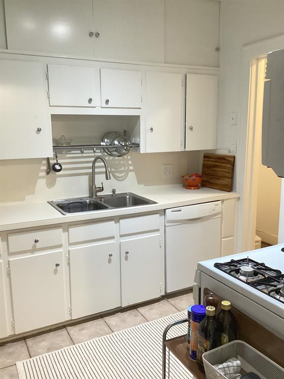 4034 Hawthorne Avenue, Unit 103 Dallas, TX 75219 - Photo 6 of 13 a kitchen with granite countertop a sink stove and white cabinets