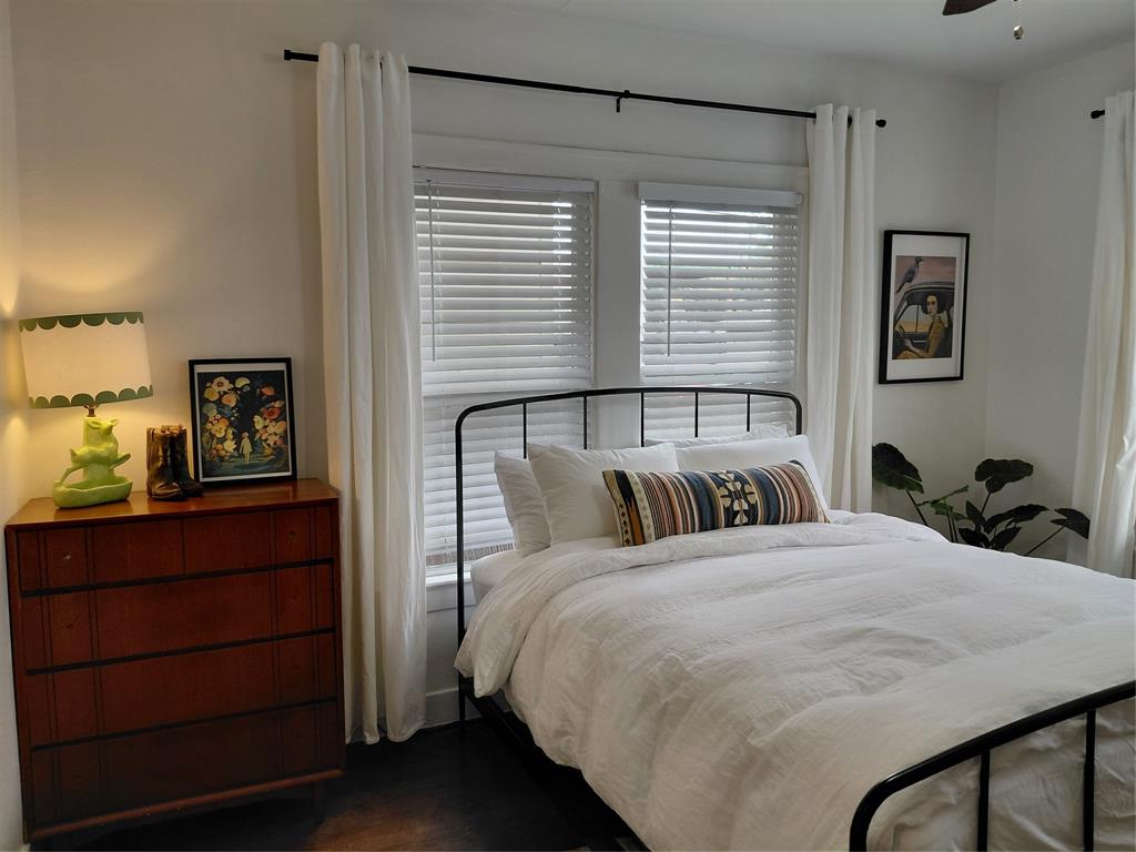4034 Hawthorne Avenue, Unit 103 Dallas, TX 75219 - Photo 10 of 13 a bed sitting in a bedroom next to a window with a dresser