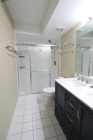 a bathroom with a granite countertop sink a toilet and shower