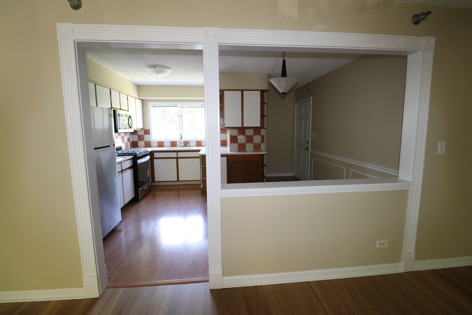112 Day Street, Unit 204 Bloomingdale, IL 60108 - Photo 9 of 17 a kitchen with kitchen island a counter top space a stove and wooden floor