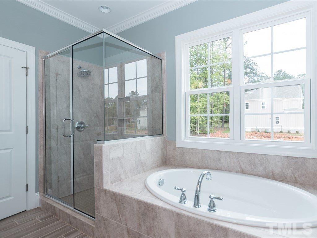 6402 Rosny Road Raleigh, NC 27613 - Photo 17 of 25 a bathroom with a bathtub and a shower