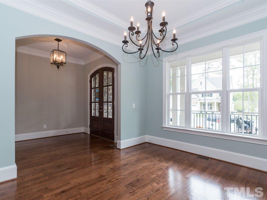 6402 Rosny Road Raleigh, NC 27613 - Photo 3 of 25 a view of an empty room with wooden floor and a window