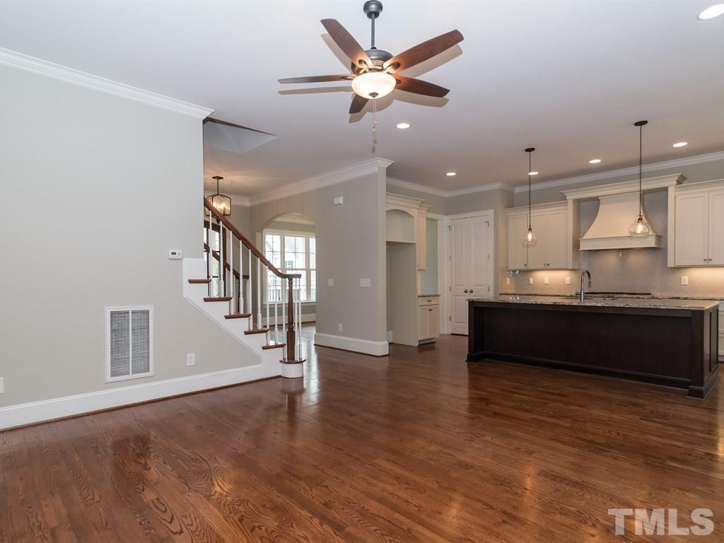 6402 Rosny Road Raleigh, NC 27613 - Photo 5 of 25 a view of an empty room with wooden floor and a ceiling fan