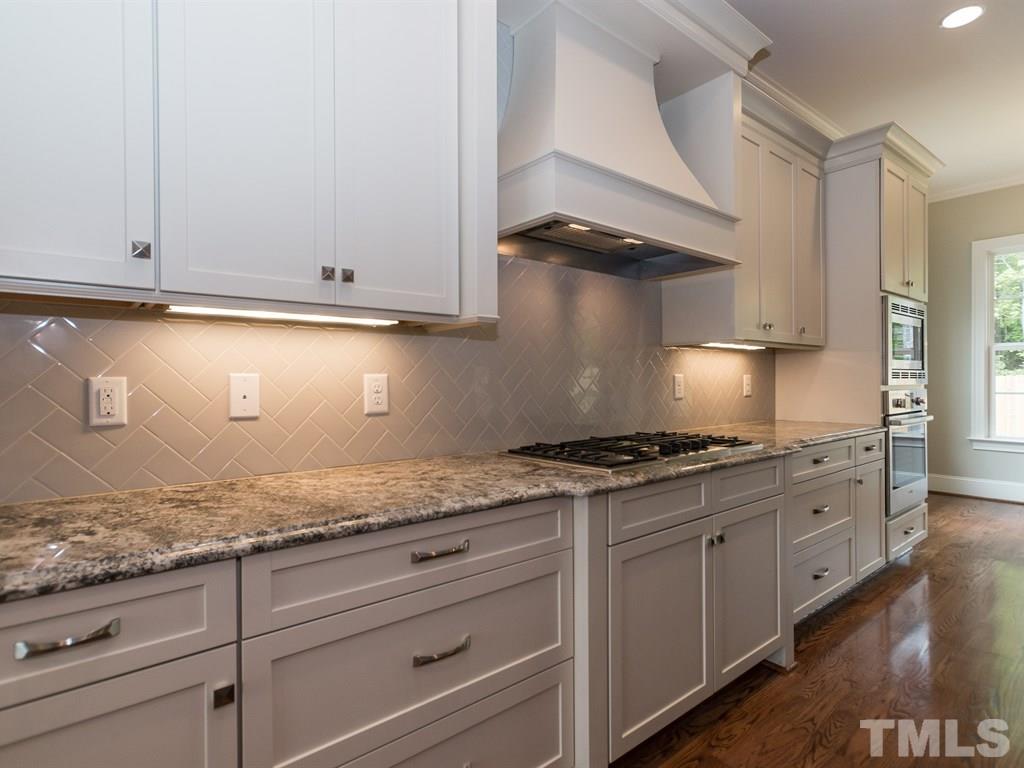 6402 Rosny Road Raleigh, NC 27613 - Photo 8 of 25 a kitchen with granite countertop white cabinets and a stove