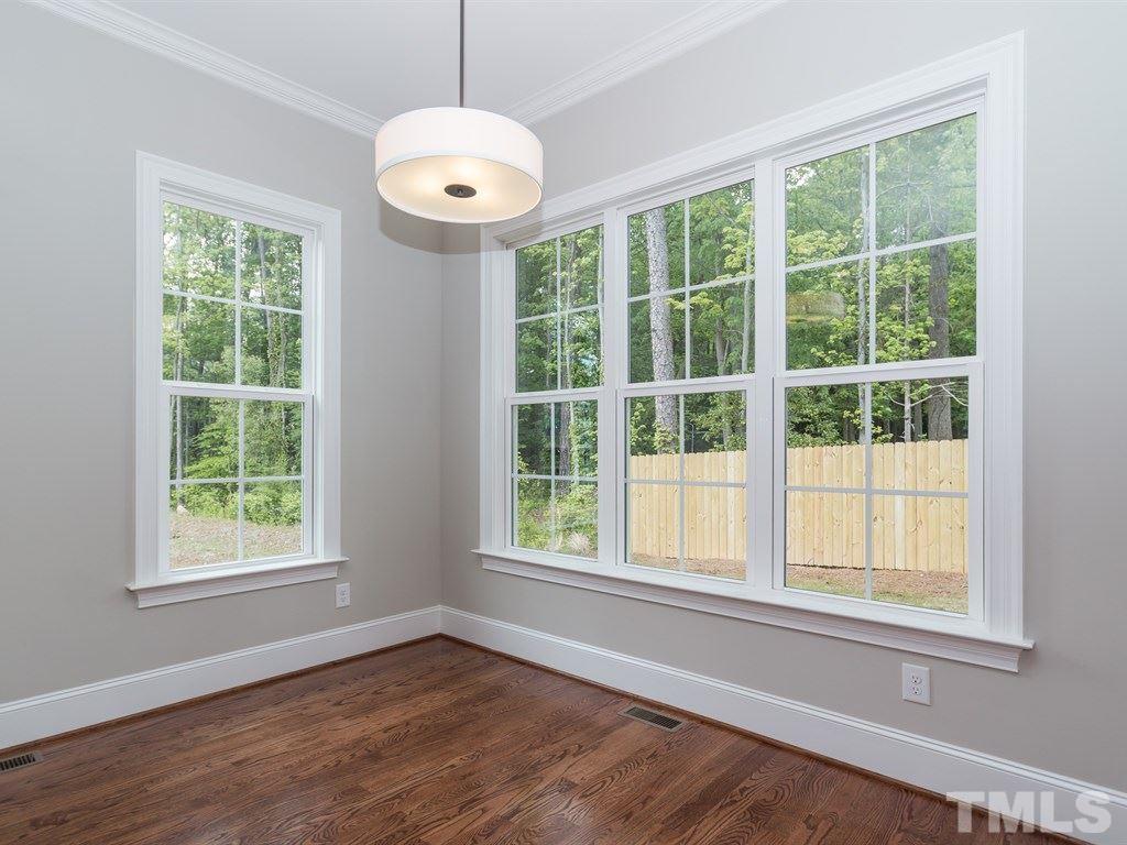 6402 Rosny Road Raleigh, NC 27613 - Photo 10 of 25 an empty room with wooden floor and windows
