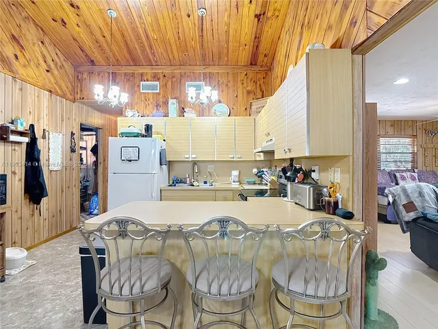 a dining hall with stainless steel appliances granite countertop a stove a sink and a refrigerator