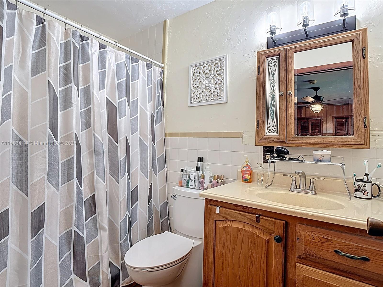 4419 Loblolly Bay Road Southwest LaBelle, FL 33935 - Photo 20 of 49 a bathroom with a sink a toilet and shower curtain