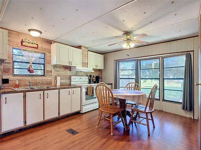 a dining room with stainless steel appliances kitchen island granite countertop a table chairs and a refrigerator