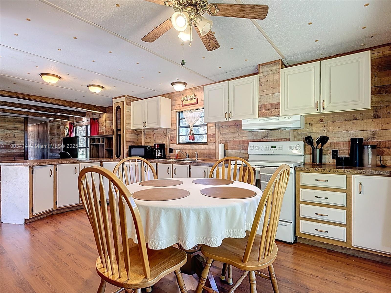 4419 Loblolly Bay Road Southwest LaBelle, FL 33935 - Photo 35 of 49 a dining room with stainless steel appliances kitchen island granite countertop a table chairs and a refrigerator