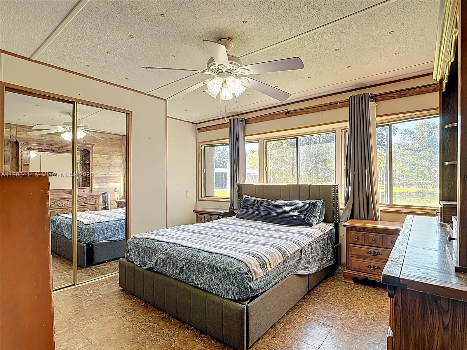 4419 Loblolly Bay Road Southwest LaBelle, FL 33935 - Photo 38 of 49 a bedroom with a large bed and a chandelier