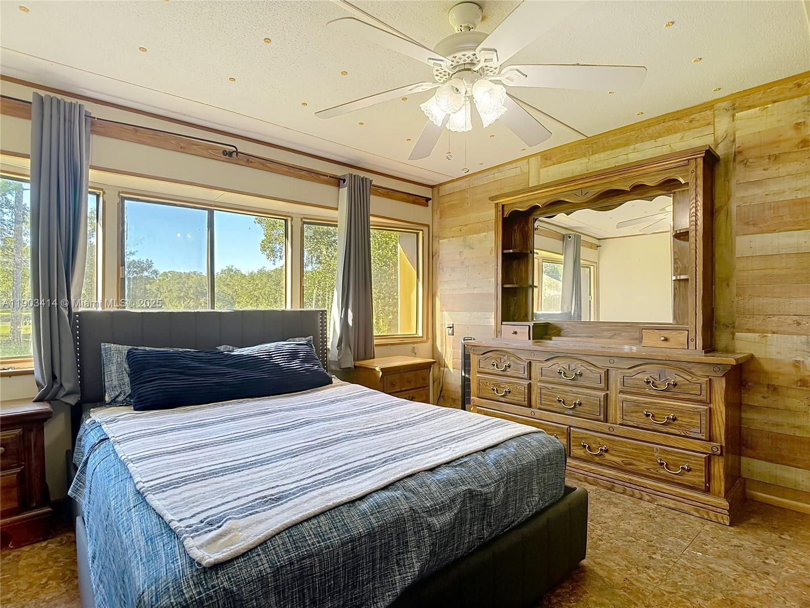 4419 Loblolly Bay Road Southwest LaBelle, FL 33935 - Photo 39 of 49 a bedroom with a large bed and a chandelier