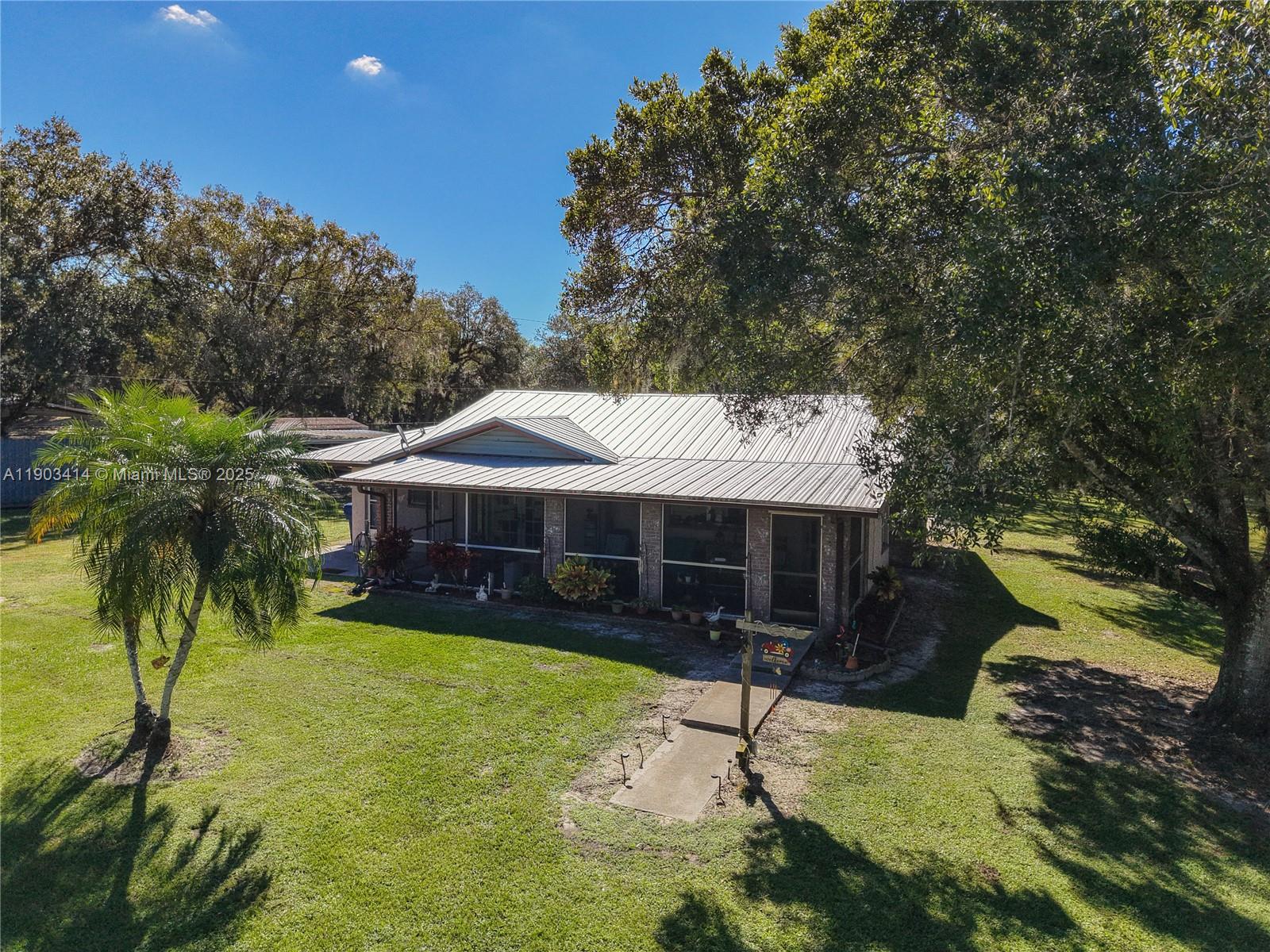 4419 Loblolly Bay Road Southwest LaBelle, FL 33935 - Photo 8 of 49 a view of a house with swimming pool and a yard