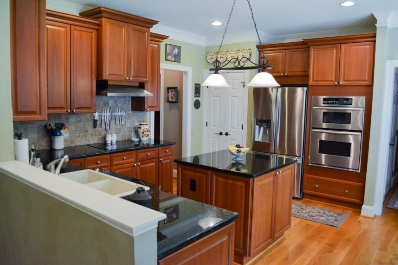 3524 Layton Ridge Drive Apex, NC 27539 - Photo 7 of 25 The beautiful kitchen features custom cherry cabinets, granite counters, large island, Stainless Steel oven and a custom cherry panes to match the cabinets to match the cabinets. Kitchen
